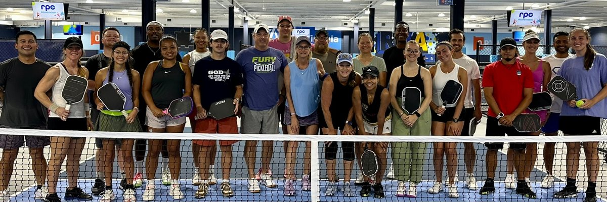 Indoor pickleball tournament with multiple courts and spectators